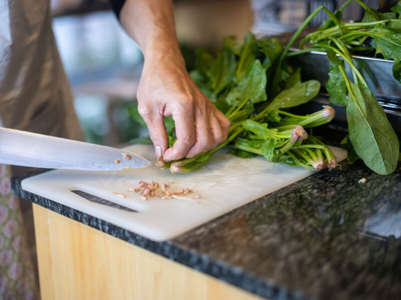 A closeup of vegetables being chopped at a cooking class